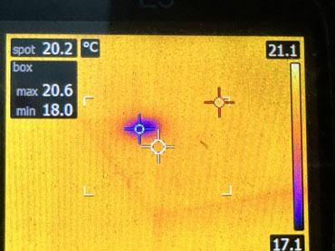 Darker area on thermal image, indicating possible moisture
